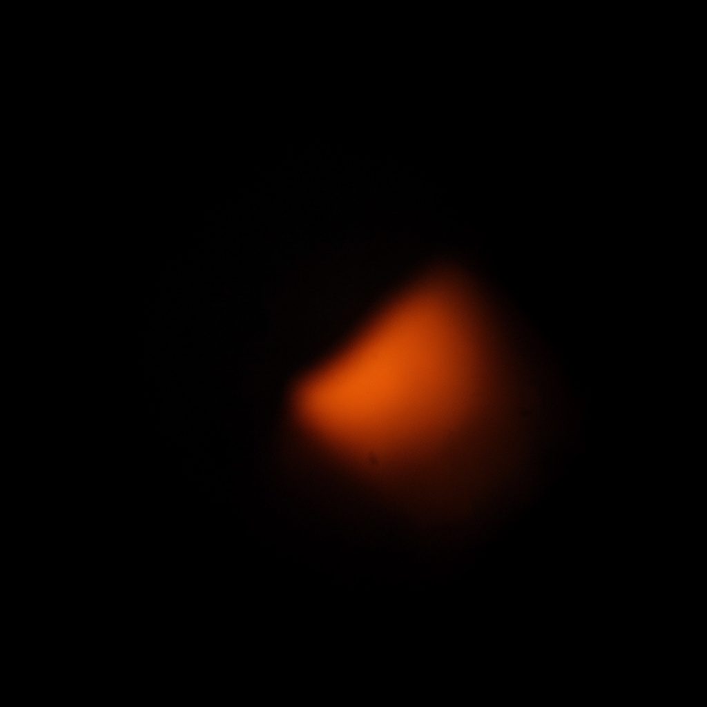 A cropped dark photograph of a virtual reality headset detail, shadowy and muted with a touch of orange highlight